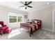 Well-lit bedroom featuring a cozy chair and a view to the backyard at 13215 Claysparrow Rd, Charlotte, NC 28278