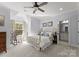 Bright bedroom featuring a brass bed frame, sitting chair and ensuite bathroom at 13215 Claysparrow Rd, Charlotte, NC 28278