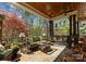 Spacious covered patio with stone flooring, comfortable seating, ceiling fan, and views of a lush backyard at 13215 Claysparrow Rd, Charlotte, NC 28278