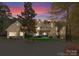 Stunning two-story home featuring a circular driveway and craftsman style architecture during a beautiful sunset at 13215 Claysparrow Rd, Charlotte, NC 28278