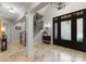 Elegant foyer with marble floors, a decorative front door, and a staircase leading to the upper level at 13215 Claysparrow Rd, Charlotte, NC 28278
