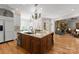 Spacious kitchen island with seating, open to a living area with stone fireplace at 13215 Claysparrow Rd, Charlotte, NC 28278