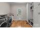 Well-lit laundry room features modern washer and dryer, storage cabinets, and a granite countertop folding area at 13215 Claysparrow Rd, Charlotte, NC 28278