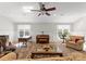 Open living room with a piano, large windows, hardwood floors, and comfortable furniture at 13215 Claysparrow Rd, Charlotte, NC 28278