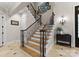 Beautiful staircase featuring iron spindles, wood treads, and a decorative wall sconce at 13215 Claysparrow Rd, Charlotte, NC 28278