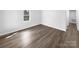 A bright bedroom featuring sleek hardwood floors, a large window, and neutral wall paint at 134 Burke Cir, Mooresville, NC 28115