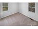 A cozy bedroom featuring neutral carpet, two windows, and neutral wall paint at 134 Burke Cir, Mooresville, NC 28115
