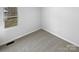 A vacant bedroom with gray carpet and a window allowing natural light to stream in at 134 Burke Cir, Mooresville, NC 28115