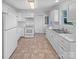 All-white kitchen featuring tile floor, ample cabinet space, and modern appliances at 134 Burke Cir, Mooresville, NC 28115