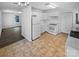 An open kitchen featuring white cabinets, tiled floors, and modern appliances including a stove and refrigerator at 134 Burke Cir, Mooresville, NC 28115