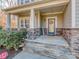 Covered porch with stone columns, decorative front door with sidelights, and a welcoming entryway at 1400 Huntcliff Dr, Waxhaw, NC 28173