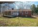 View of brick home with deck and screened-in porch overlooking backyard with mature trees at 1547 Kings Rd, Shelby, NC 28150