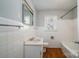 Classic bathroom with white tile, a window, and wood-look flooring, creating a clean and functional space at 1547 Kings Rd, Shelby, NC 28150