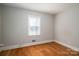 Bedroom featuring hardwood floors, white trim, and a window providing natural light, creating a simple and inviting atmosphere at 1547 Kings Rd, Shelby, NC 28150