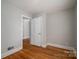 Bedroom featuring hardwood floors, white trim, and an open closet door, creating a simple and inviting atmosphere at 1547 Kings Rd, Shelby, NC 28150