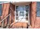 Close-up of the front door with glass panels, brick accents, and a small porch area at 1547 Kings Rd, Shelby, NC 28150