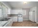 Traditional kitchen featuring white appliances, cabinets, and a double-basin sink, offering a clean and functional space at 1547 Kings Rd, Shelby, NC 28150