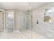 A modern bathroom features a glass shower with marble tile, sleek fixtures, and a window offering natural light at 2069 Landry Ln # 233, Rock Hill, SC 29732