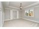 A spacious bedroom with neutral tones, carpet, large window, and coffered ceiling with modern chandelier at 2069 Landry Ln # 233, Rock Hill, SC 29732