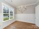 Dining room boasts hardwood floors, wainscoting and a modern chandelier, with a large window overlooking the yard at 2069 Landry Ln # 233, Rock Hill, SC 29732