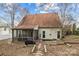 Spacious backyard featuring a screened porch, lush landscaping, and a charming exterior view of the home at 207 Pebble Creek Xing, Fort Mill, SC 29715