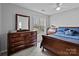 Spacious bedroom featuring a large window, a wooden dresser, and a neatly made bed with stylish pillows at 207 Pebble Creek Xing, Fort Mill, SC 29715