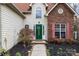 A charming home with a green front door and beautiful brick accents, surrounded by fresh landscaping at 207 Pebble Creek Xing, Fort Mill, SC 29715