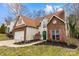 Lovely two-story home with brick accents and a green front door, set amidst lush landscaping at 207 Pebble Creek Xing, Fort Mill, SC 29715