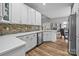 Modern kitchen with white cabinets, a mosaic backsplash, stainless steel appliances, and hardwood floors at 207 Pebble Creek Xing, Fort Mill, SC 29715