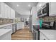 Well-lit kitchen featuring modern appliances, white cabinetry, and open layout to dining area at 207 Pebble Creek Xing, Fort Mill, SC 29715
