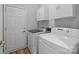Functional laundry room with modern washer and dryer units, storage cabinets, and convenient access to the rest of the home at 207 Pebble Creek Xing, Fort Mill, SC 29715