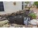 Detailed view of a tranquil backyard pond with rock accents and water feature at 207 Pebble Creek Xing, Fort Mill, SC 29715