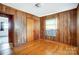 Bedroom with wood paneling, window and access to additional rooms at 222 Weldon Cir, Mount Holly, NC 28120