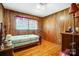 Wood paneled bedroom featuring wood floors, a window, and a closet at 222 Weldon Cir, Mount Holly, NC 28120