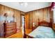 Cozy bedroom with natural wood paneling, wood floors and classic furnishings at 222 Weldon Cir, Mount Holly, NC 28120
