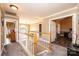 Bright hallway with carpet, wooden railing staircase, and an open doorway at 2622 Rolling Ridge Dr, Hickory, NC 28602