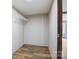 A small closet with brown vinyl floors, light-gray walls, a wire shelf, and a wooden door frame at 3365 34Th Avenue Ne Ct, Hickory, NC 28601