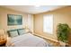 Comfortable bedroom with light yellow walls, wood-look floors, and a queen-sized bed with teal pillows at 343 Bell St, Mooresville, NC 28115