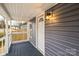 Close up of the entry porch featuring a white door with half-round window and an outdoor light fixture at 343 Bell St, Mooresville, NC 28115