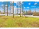 Wide-angle backyard showcasing mature trees, fencing, and additional storage building at 348 Fleetwood Rd, York, SC 29745