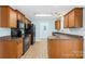 Functional kitchen featuring modern black appliances, wood cabinetry, and tile flooring at 348 Fleetwood Rd, York, SC 29745