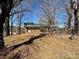 View of a brick home nestled in a treed lot, showcasing its simple architectural style at 4073 Lee Cline Rd, Conover, NC 28613