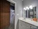 Bathroom featuring a vanity, sink, mirror, and a view to a bedroom with exposed brick at 4080 Elks Park Rd, Rock Hill, SC 29732