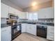 Kitchen features white cabinetry, wood floor, and black appliances at 4080 Elks Park Rd, Rock Hill, SC 29732