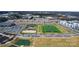 Aerial view highlighting community sports amenities: field, tennis, playground, with nearby parking, and townhome community at 419 Burr St, Indian Trail, NC 28079