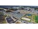 Wide aerial view highlighting community athletic facilities, parking and a pond with walking bridge nearby new townhomes at 419 Burr St, Indian Trail, NC 28079