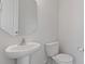 Clean, well-lit bathroom features a pedestal sink, toilet, and a neutral color palette at 419 Burr St, Indian Trail, NC 28079