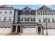 Three-story townhome exteriors boast stone accents, varied siding colors, and private one-car garages at 419 Burr St, Indian Trail, NC 28079