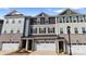 Up close, the townhomes feature a blend of colors in their siding and a foundation of textured stone at 419 Burr St, Indian Trail, NC 28079