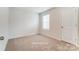 Bedroom with neutral colored walls and carpet, and natural light from a window at 6419 Mallow Crossing Ln, Charlotte, NC 28213